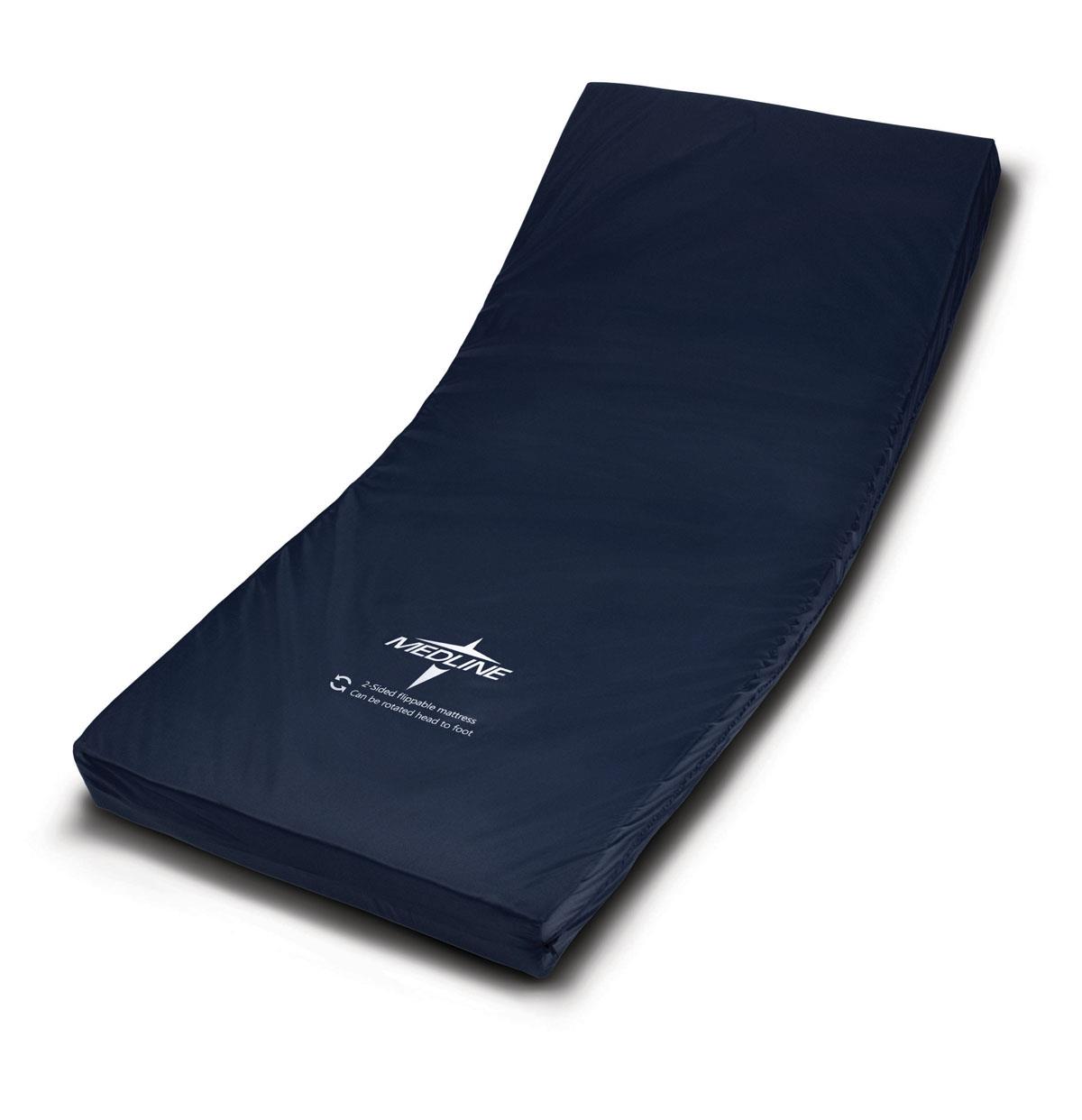 Foam hospital bed mattress with navy blue cover, shown at an angle on white background