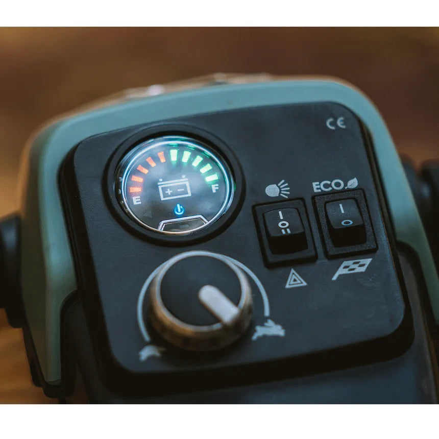 Power wheelchair control panel showing lit battery gauge, speed dial, lights toggle, and ECO mode switch