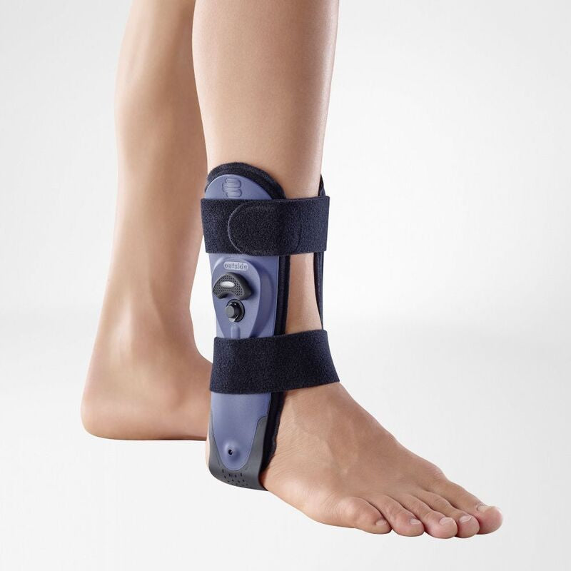 Ankle brace with rigid blue plastic shell and two navy hook-and-loop straps worn on a bare right foot and lower leg