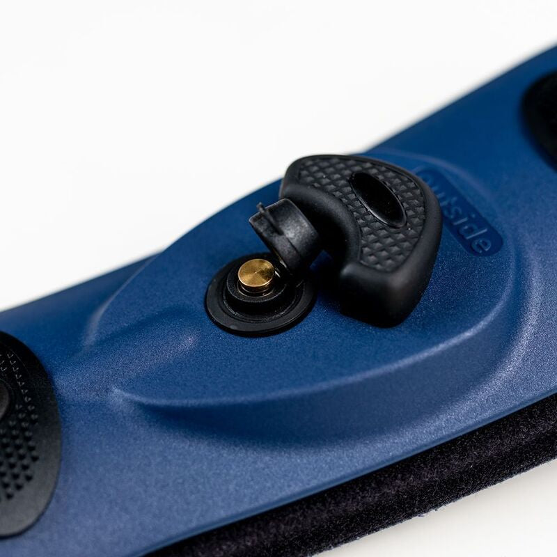 Ankle brace close-up showing blue rigid shell with black textured buckle closure mechanism and brass pivot screw, labeled