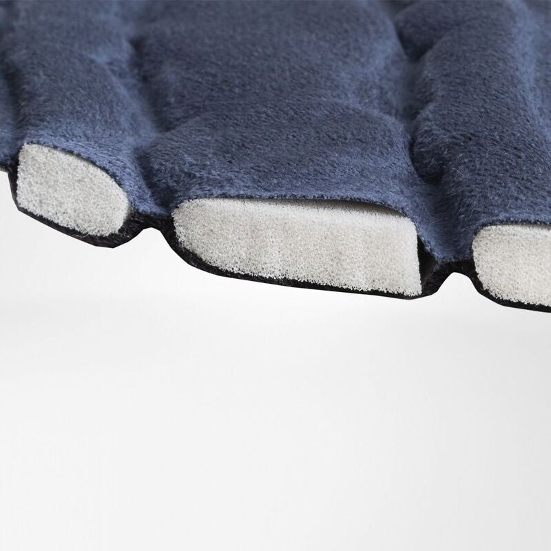 Ankle brace close-up showing navy blue fabric exterior with segmented foam padding cells visible along the trimmed edge