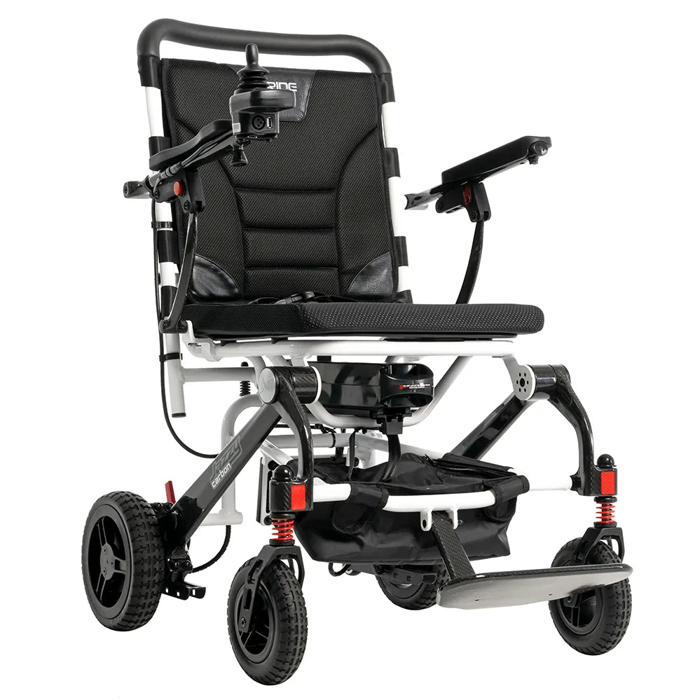 Power wheelchair with black padded seat and backrest, joystick control, white and black frame, red suspension springs, and