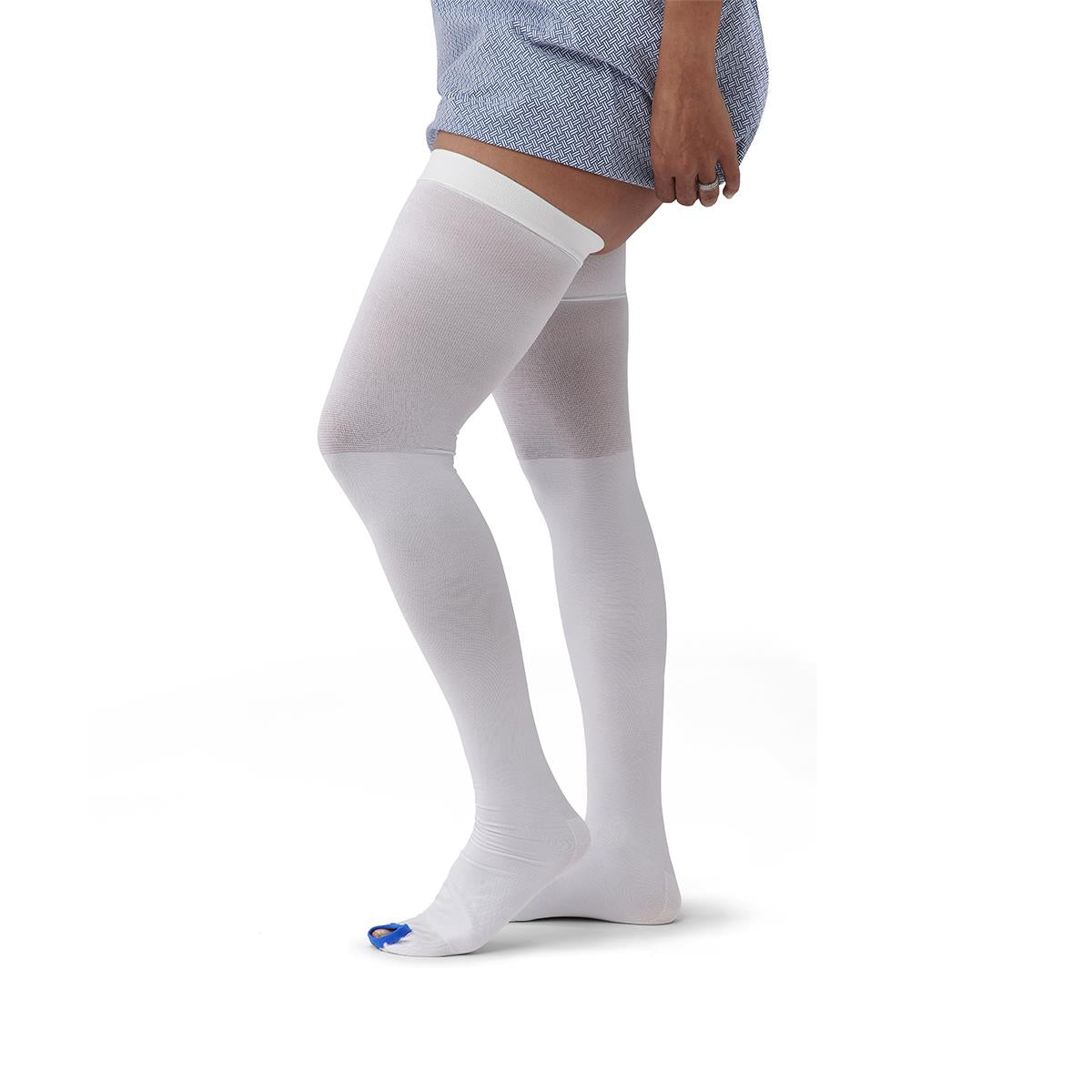 Thigh-length anti-embolism stockings in white with open toe shown on a person's legs, reaching upper thigh
