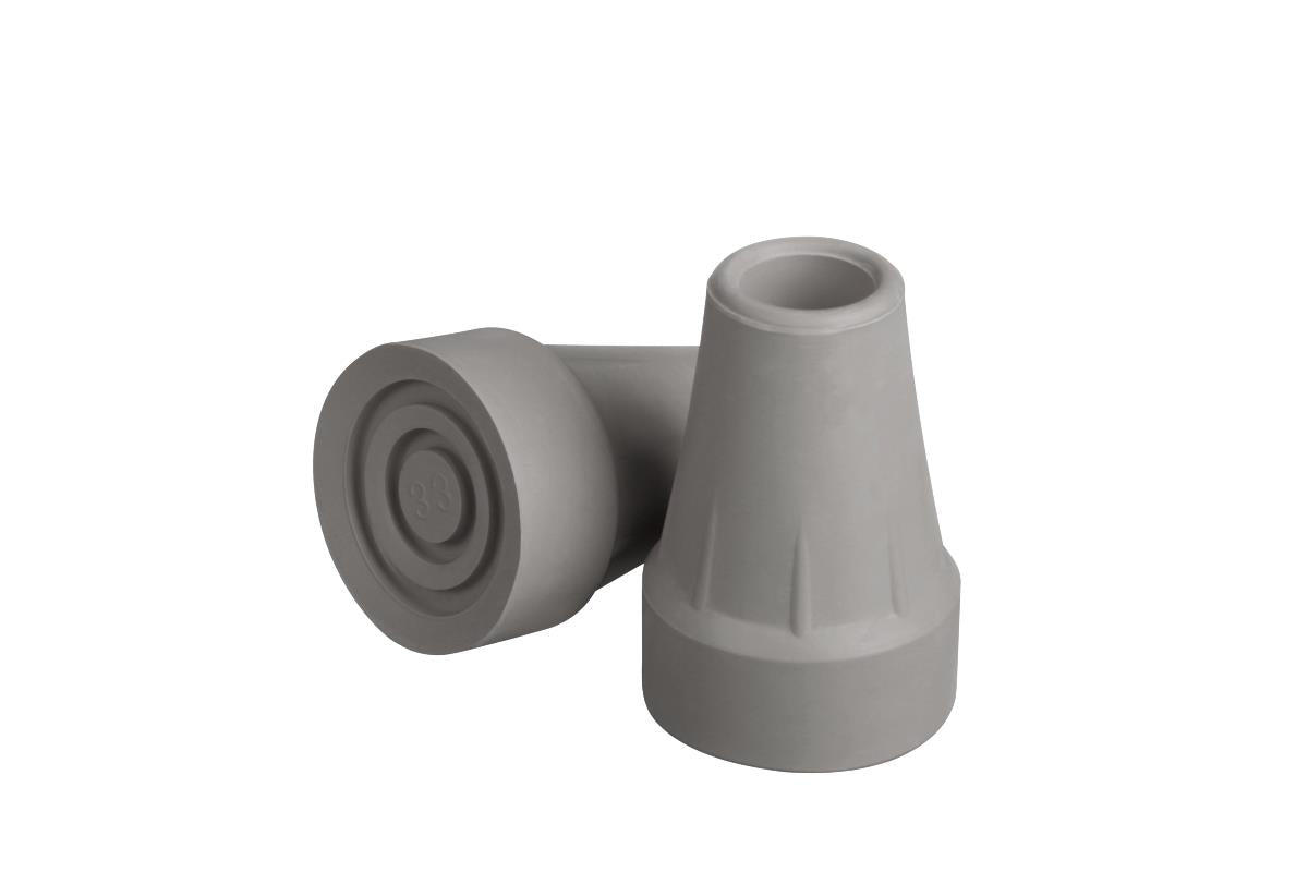 Pair of gray rubber crutch tips, one upright showing hollow opening and one tipped showing textured bottom with concentric