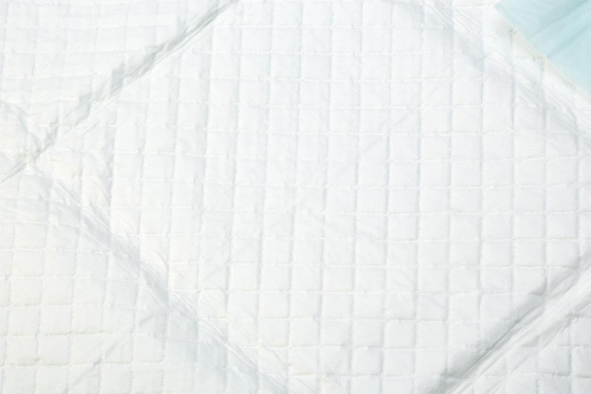Disposable underpad with white quilted top surface and light blue waterproof backing, shown flat