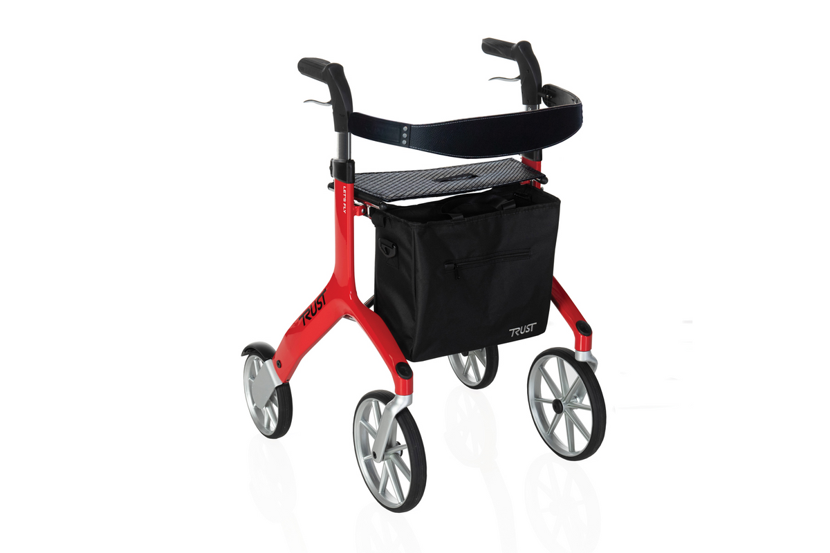 Rollator walker with red aluminum frame, four large wheels, padded seat, hand brakes, and black underseat storage bag