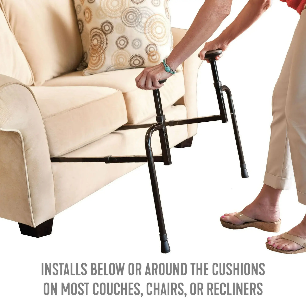 Couch stand assist rail with dual handles being positioned beside a beige sofa by a woman's hands