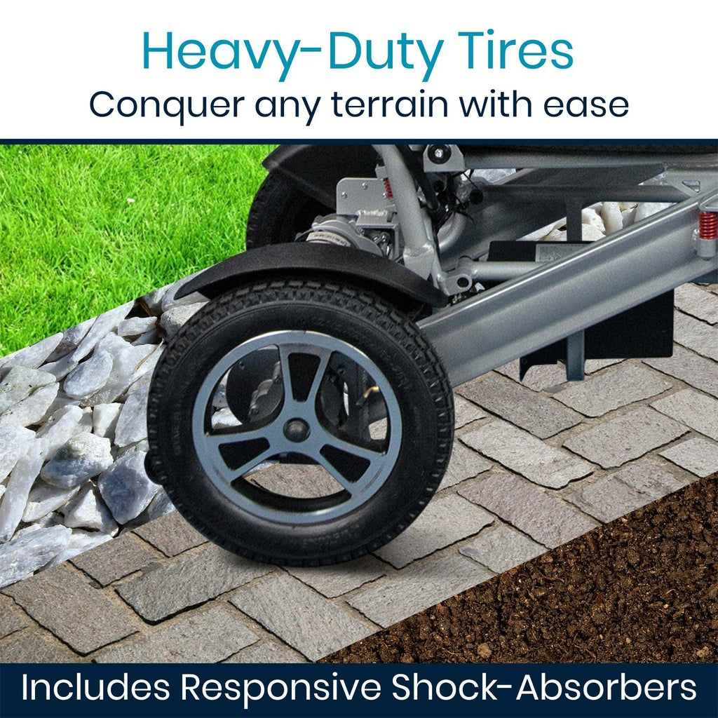 Folding power wheelchair close-up of heavy-duty tire and shock absorber on varied terrain including gravel, pavers, and grass
