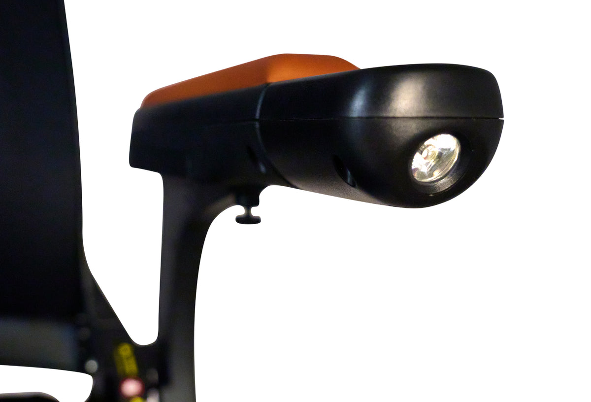 Power wheelchair tiller arm with built-in LED headlight, shown in black with orange accent against white background