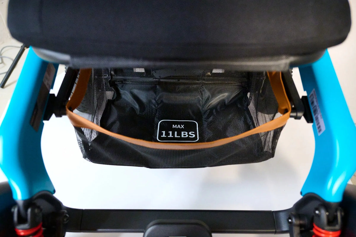 Power wheelchair underseat storage bag with mesh sides and MAX 11LBS label, mounted on teal blue frame
