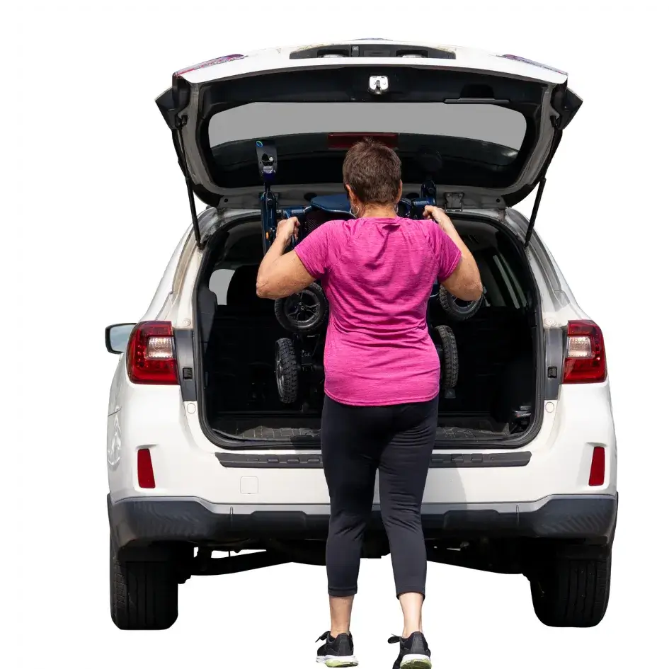 Power wheelchair being lifted into an SUV cargo area by a woman in a pink shirt, showing transport portability