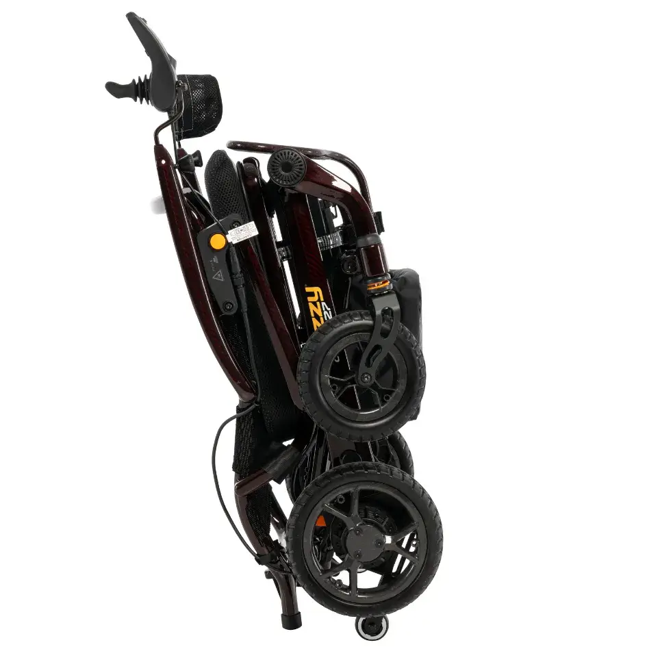 Jazzy Carbon power wheelchair folded compactly, shown in dark red with joystick controller and black wheels against white