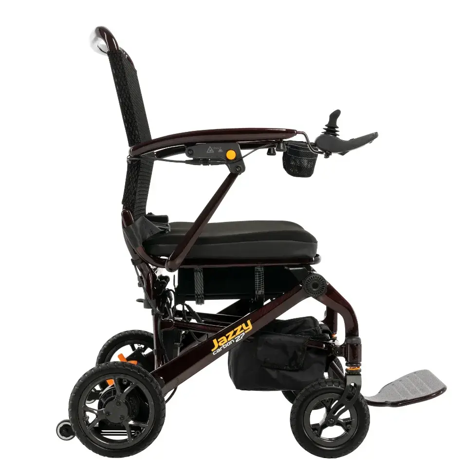Jazzy Carbon 27 power wheelchair side view with mesh high back, joystick controller, footrest, and dark red frame