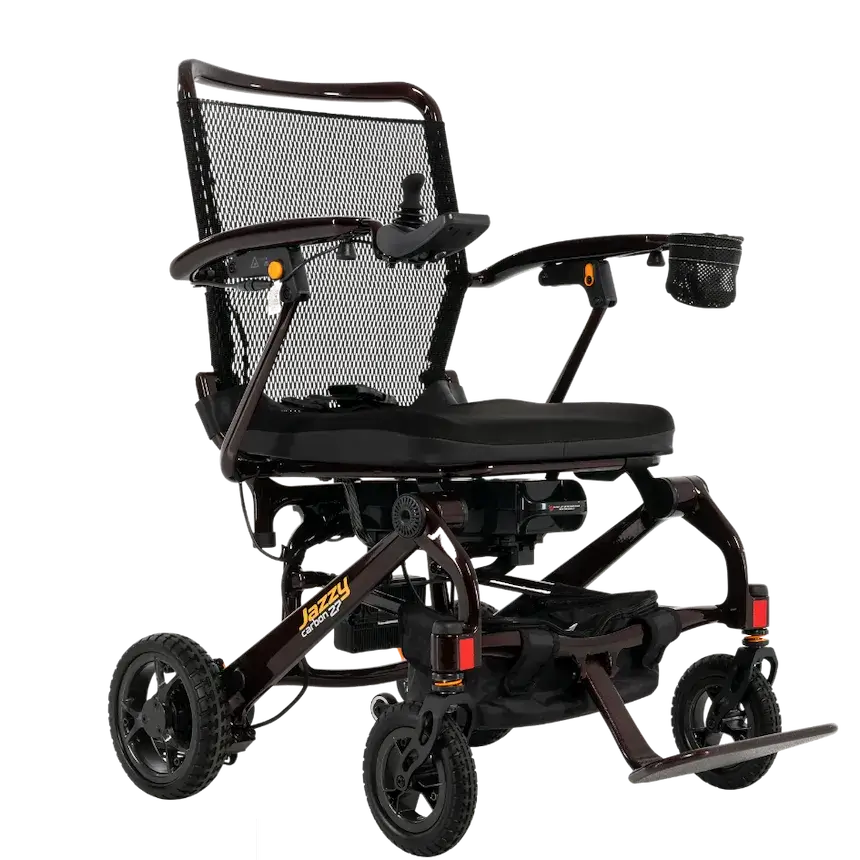 Jazzy Carbon 27 power wheelchair in dark frame with mesh back, joystick control, cup holder, and all-terrain wheels