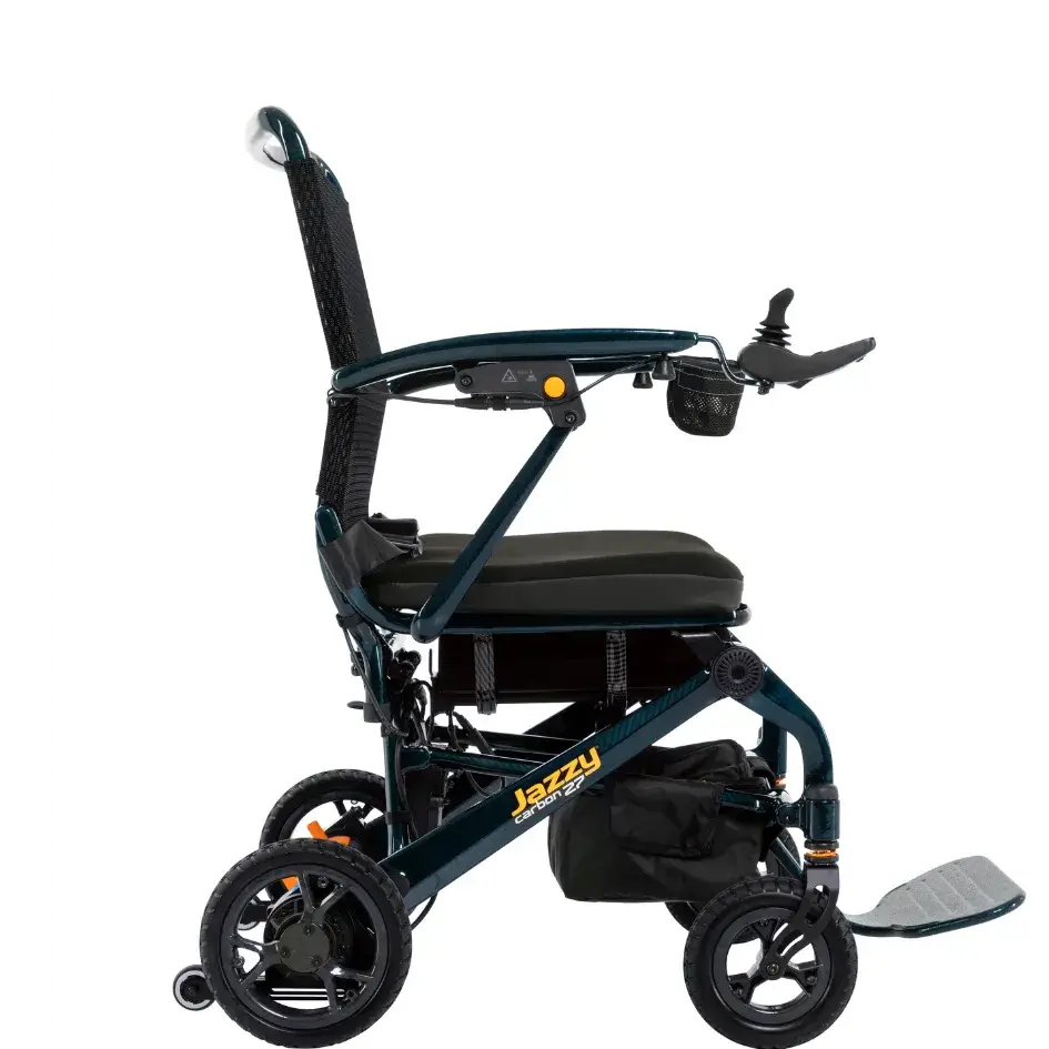 Jazzy Carbon 27 power wheelchair shown from the side, featuring a teal frame, mesh back, joystick controller, and footrest