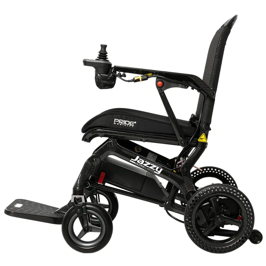 Jazzy Ultra Light power wheelchair in black carbon fiber finish, side view, with joystick controller and cup holder