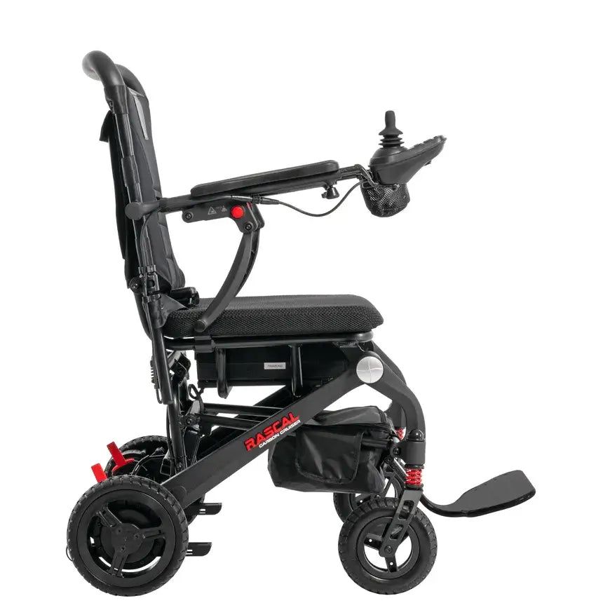 Power wheelchair in black with joystick controller, cup holder, footrest, and red accent suspension, shown from the side