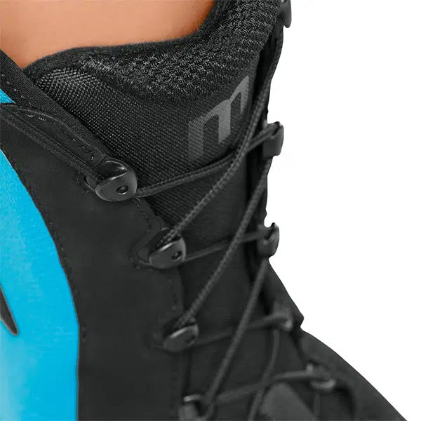 Ankle brace close-up showing black lace-up closure, padded collar, and teal rigid side panel on a foot