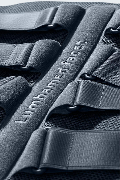 Lumbamed Facet lumbar support brace showing dark gray mesh fabric, embossed logo, and adjustable hook-and-loop closure straps