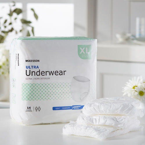 McKesson Ultra Underwear XL package of 14 beside a stack of three white adult pull-up underwear on a counter
