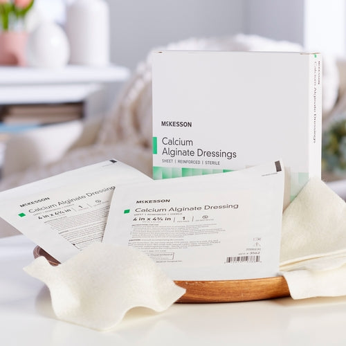 McKesson Calcium Alginate Dressings box with individual sterile packets and an unwrapped dressing displayed on a white