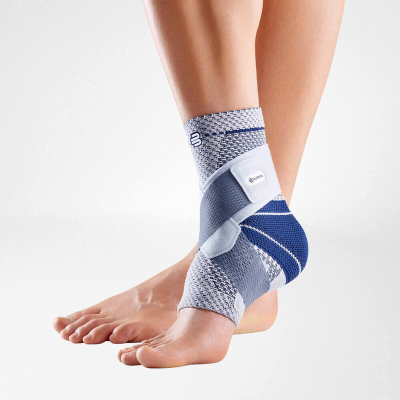 Ankle brace with gray knit fabric, blue straps, and side stabilizers worn on a bare foot and lower leg