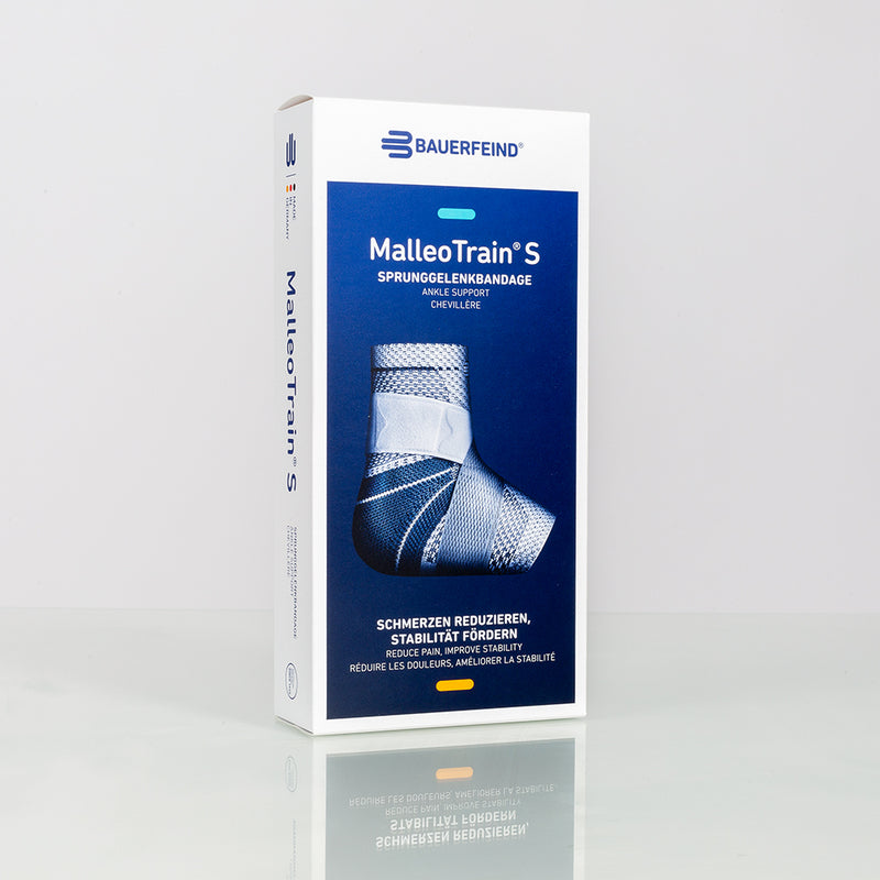 Bauerfeind MalleoTrain S ankle support brace in white and blue retail packaging on a reflective surface