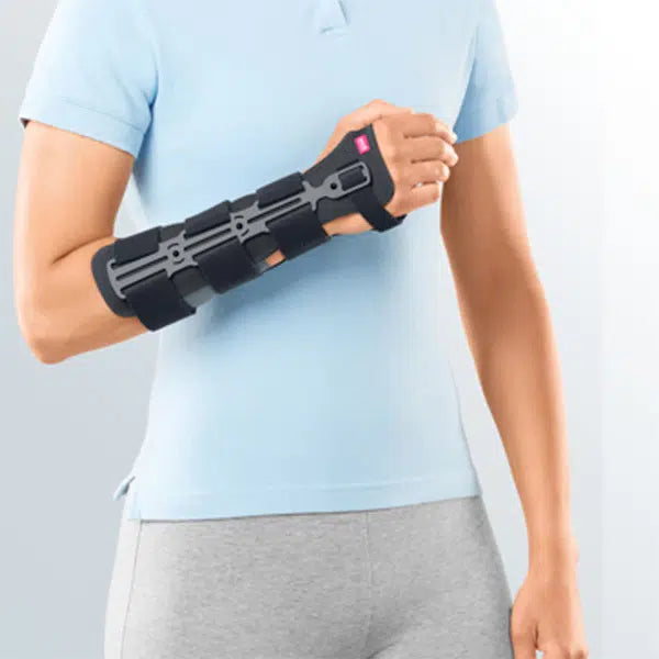 Wrist fracture brace with rigid splint and thumb support worn on a person's right forearm, shown from front view