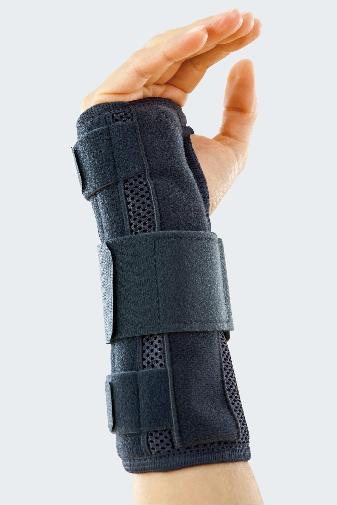 Wrist brace in dark gray with ventilation panels and two adjustable hook-and-loop straps, worn on a left hand