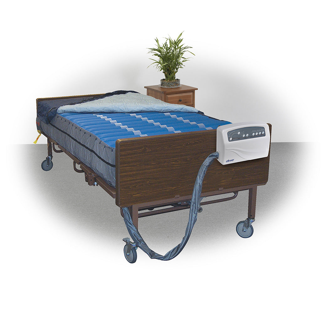 Alternating pressure mattress replacement system with blue air cells on a hospital bed frame, connected to an electric pump