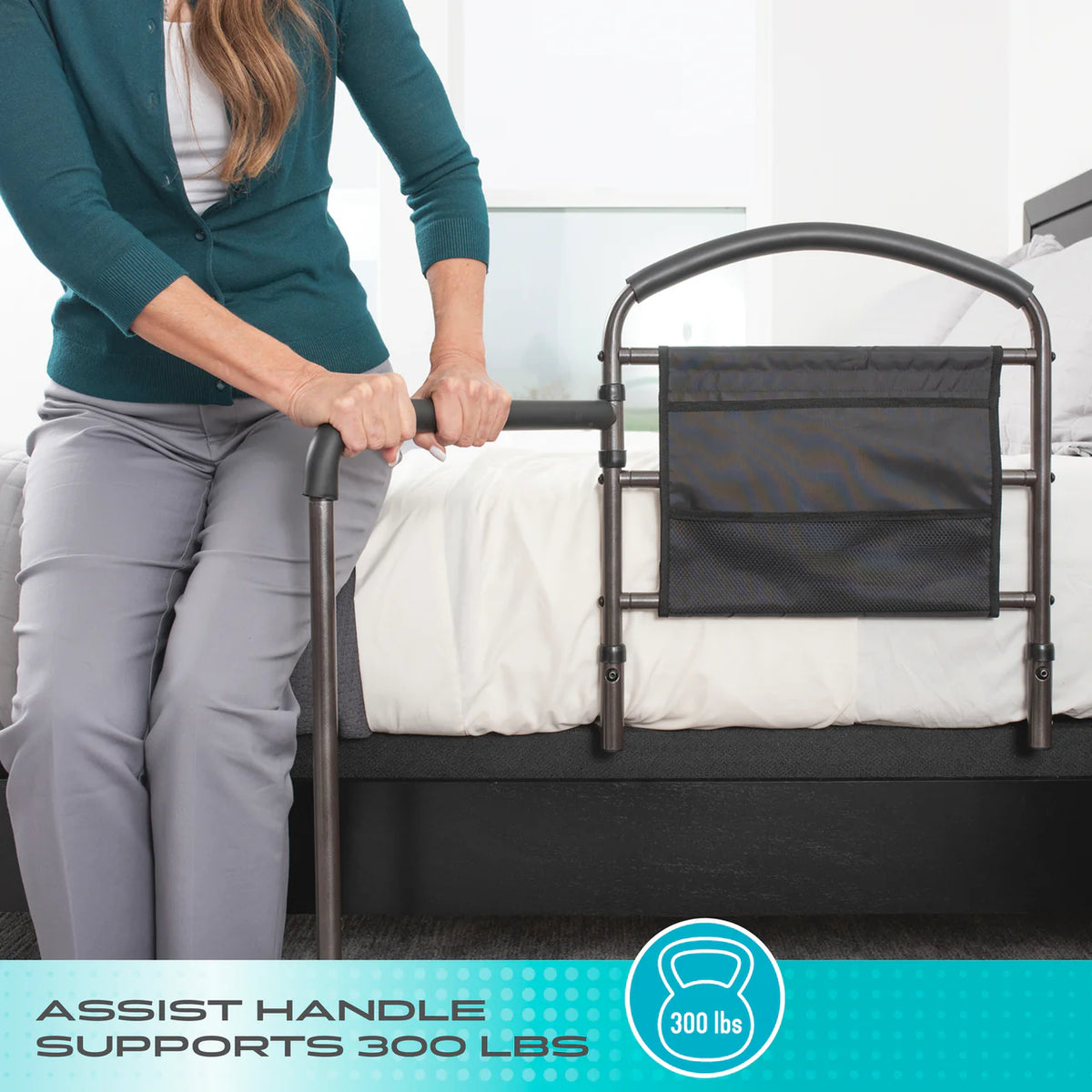 Bed rail with assist handle and mesh storage pocket mounted on a bed, shown with a woman gripping the handle while seated