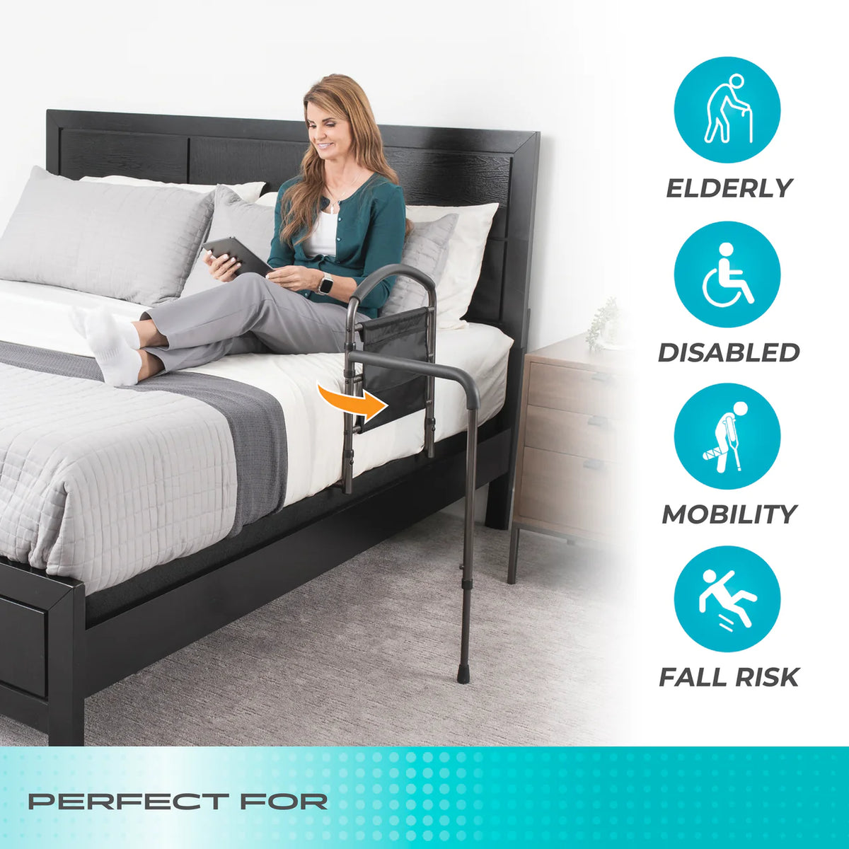 Mobility bed rail with adjustable floor support attached to a dark wood bed, with a woman sitting on the bed holding a tablet
