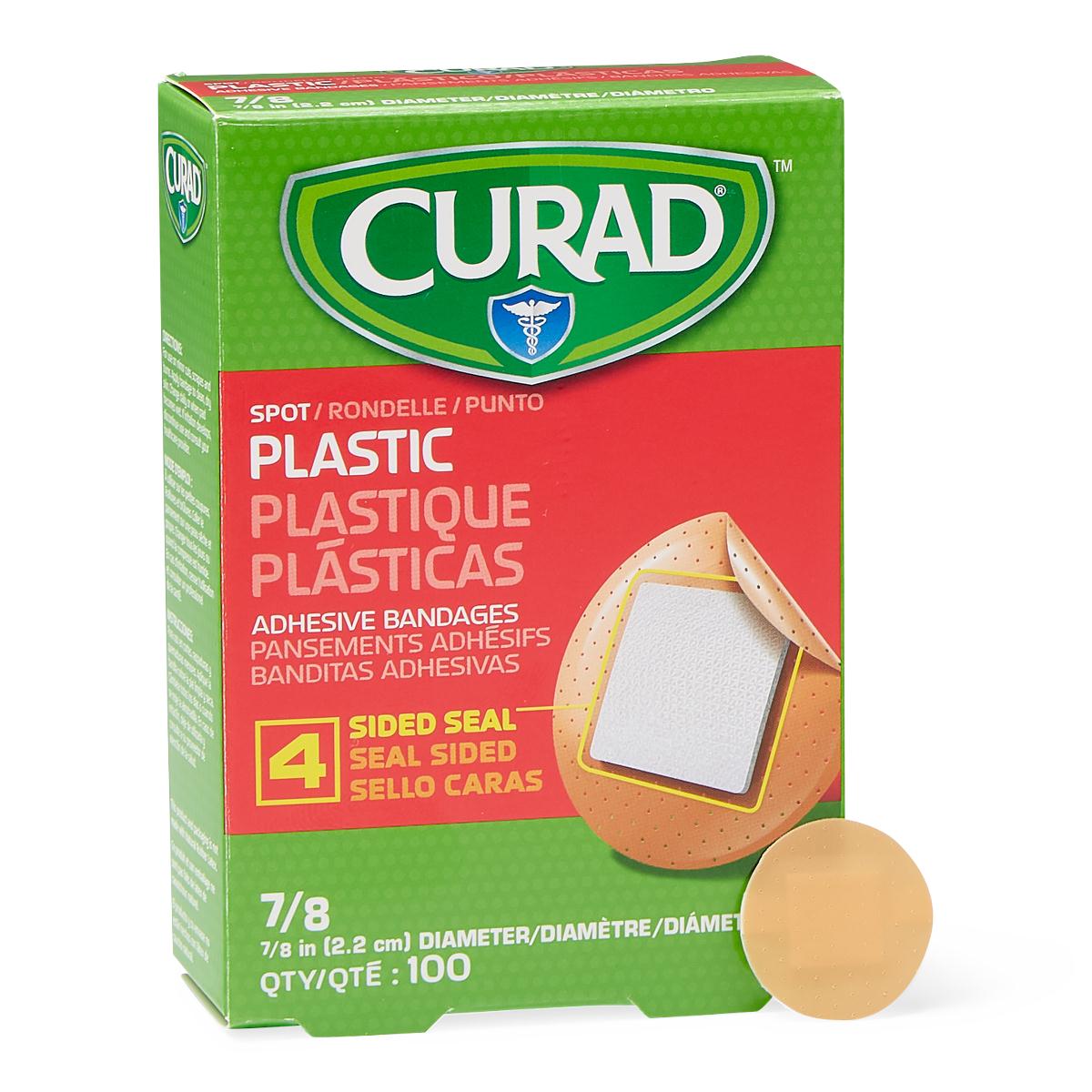 Curad plastic spot adhesive bandages green box of 100 shown with a single round tan bandage beside it