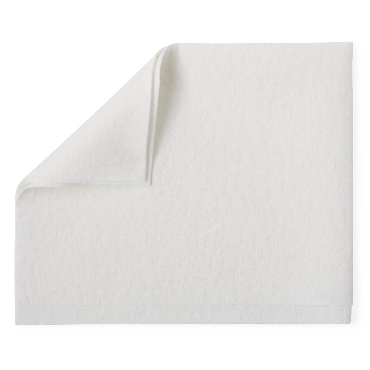 Disposable washcloth in white nonwoven fabric, shown flat with one corner folded back on a white background