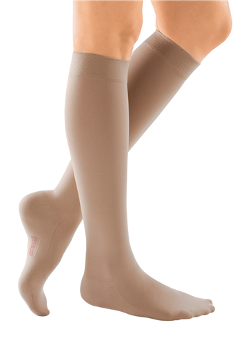 Compression socks in beige, knee-high closed toe style, shown on a person's legs from two angles