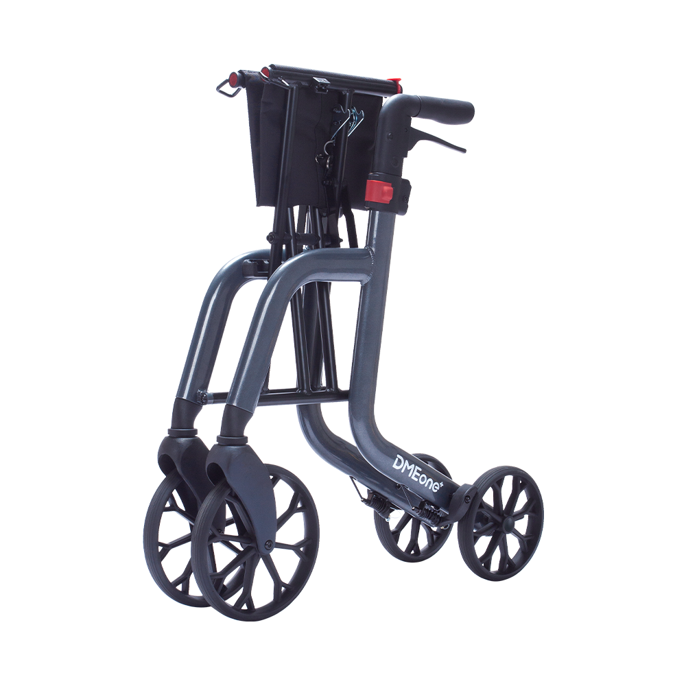 Rollator walker in folded position with gray frame, four black wheels, handlebar brakes, red accents, and black basket