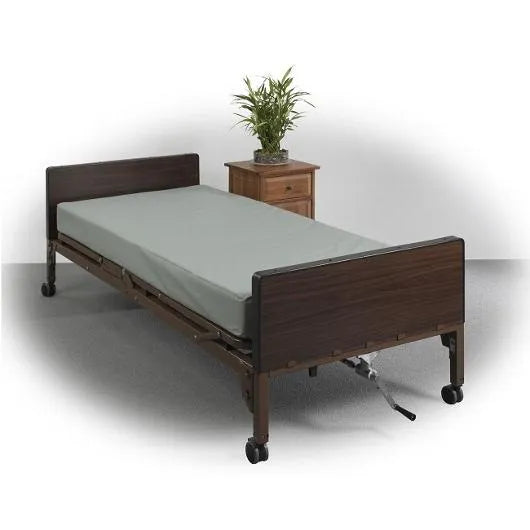 Innerspring hospital bed mattress in gray cover shown on a full electric home hospital bed with dark wood panels