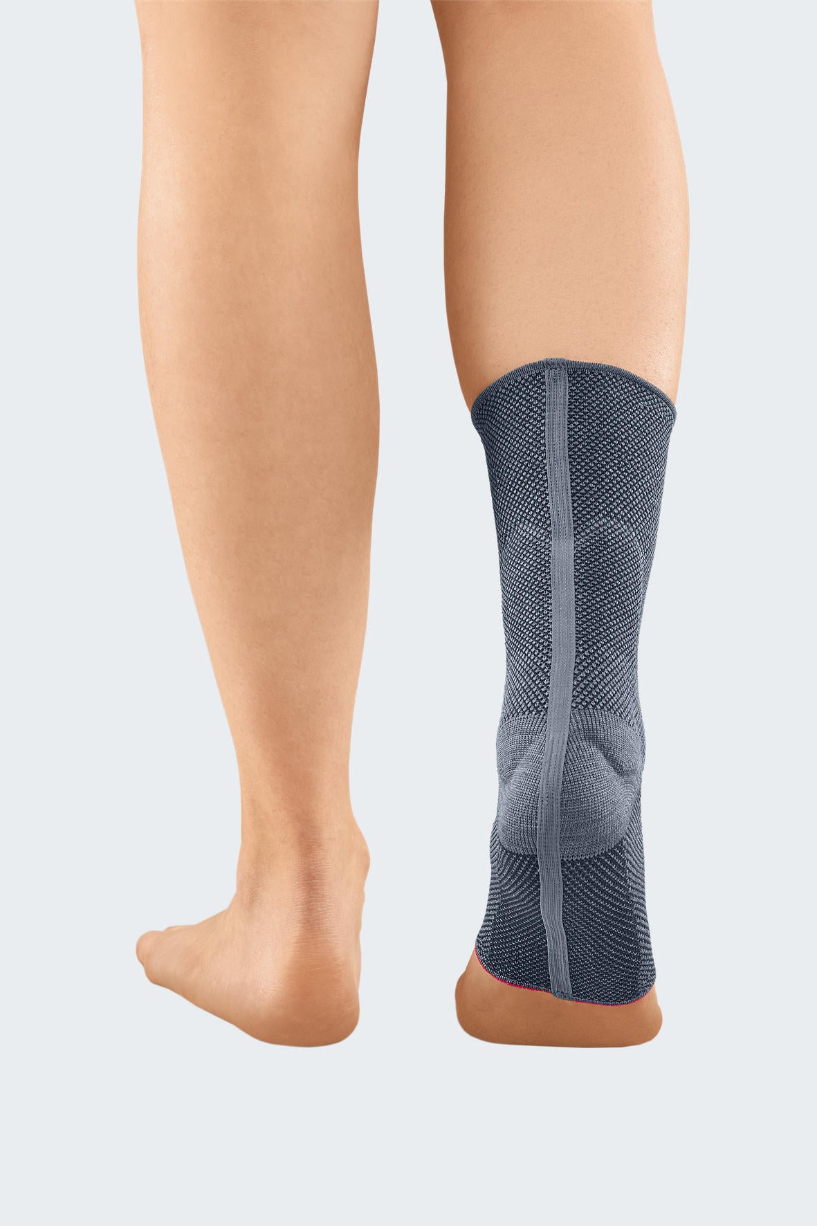Achimed ankle support in gray knit fabric worn on lower leg, rear view showing heel cup and vertical strap detail