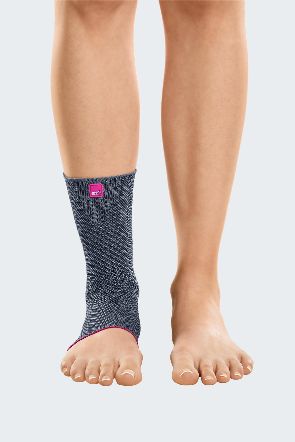 Achimed ankle support in gray knit fabric with pink trim detail, worn on left ankle, front view