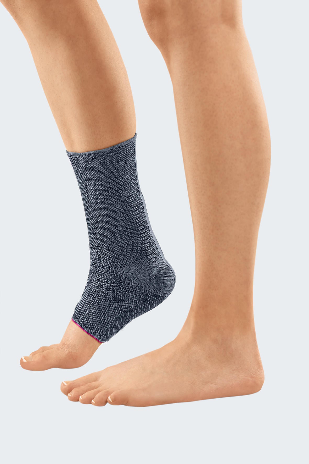 Achimed ankle support in gray knit fabric with pink accent trim, worn on a bare left foot and ankle