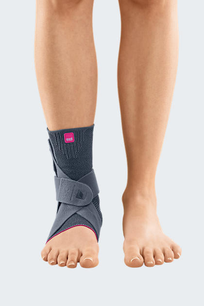 Levamed Active Ankle Support in gray with pink accents and cross-strap closure, worn on a person's left ankle, front view