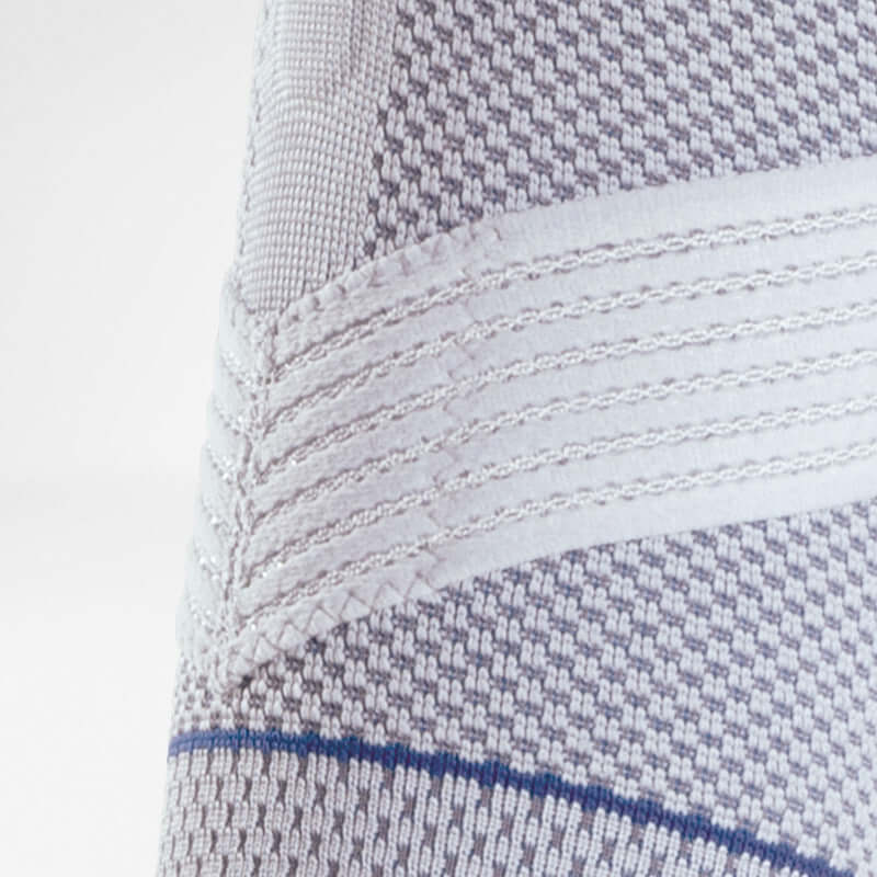 Shoulder brace close-up showing knitted fabric texture with woven support bands and blue accent stripe detail