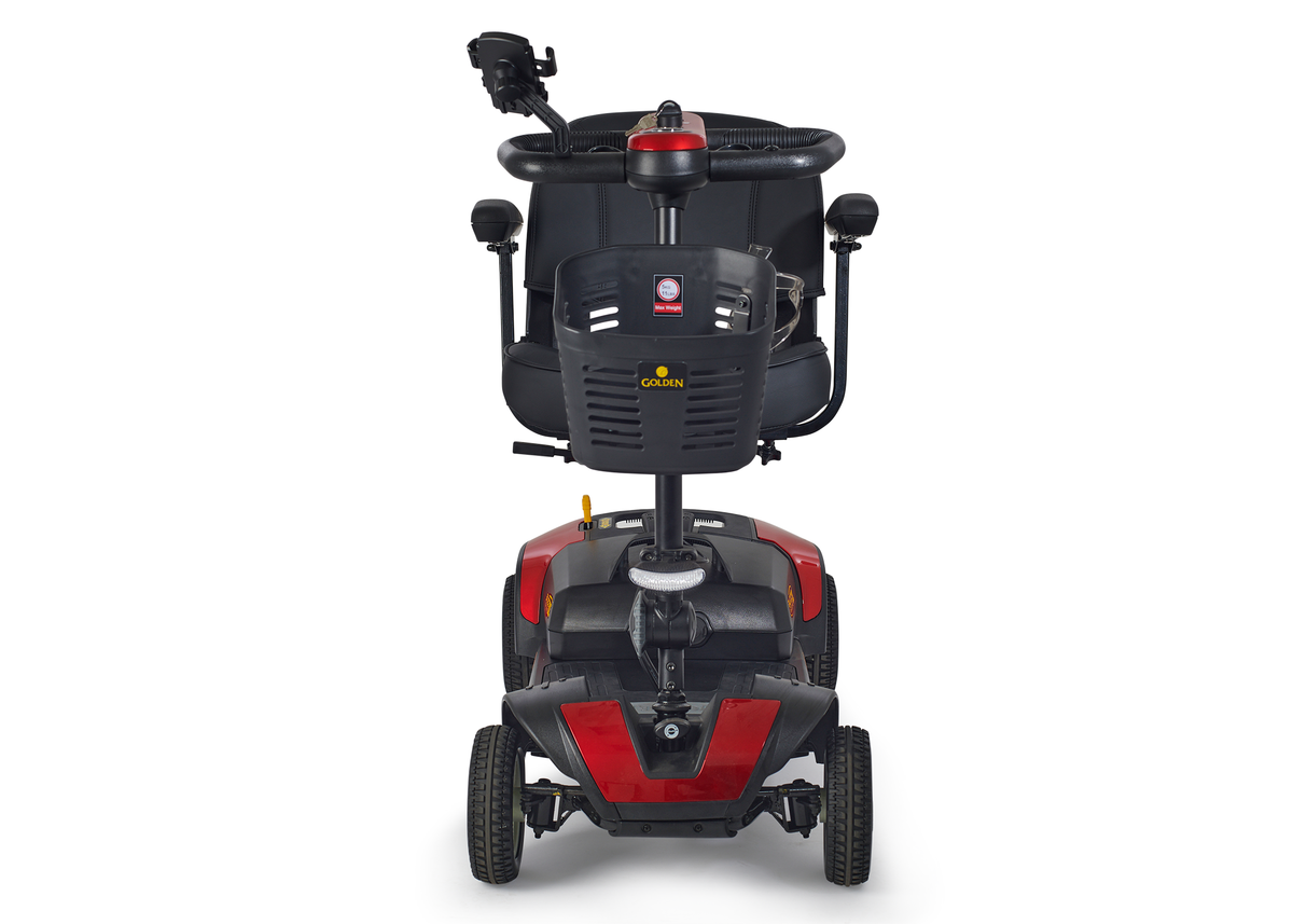 Four-wheel mobility scooter in red and black with tiller steering, padded seat, armrests, and front basket, front-facing view