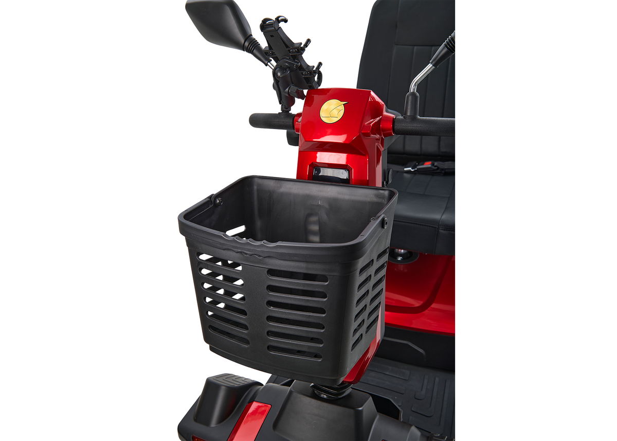 Power scooter front basket close-up showing black plastic storage basket mounted to red heavy-duty mobility scooter with