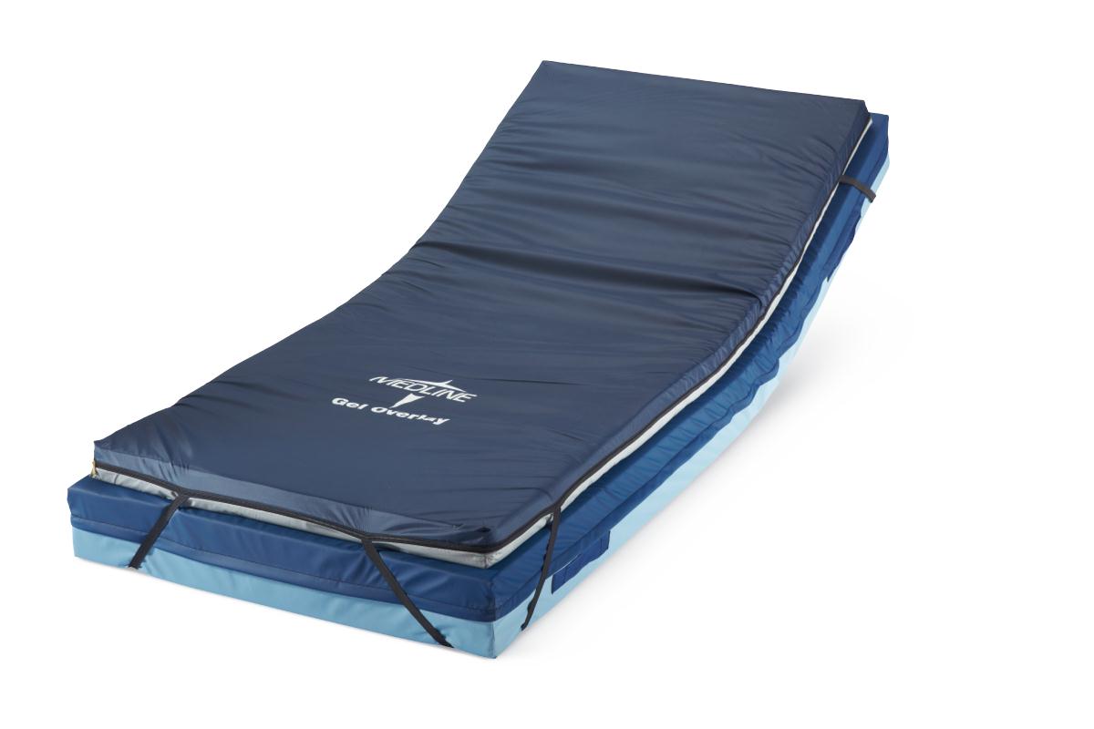 Gel foam mattress overlay with navy blue vinyl cover, corner straps, and layered foam base on white background