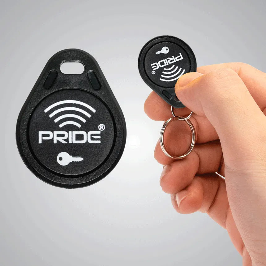 Key fob accessory with keyring shown alone and held in hand, black with Pride branding and wireless signal icon