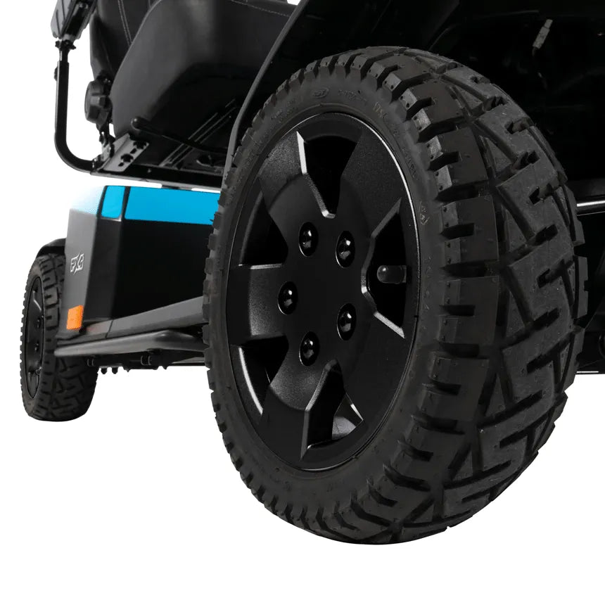 Power scooter large knobby rear drive wheel with black five-spoke hub, blue and black body panel visible in background