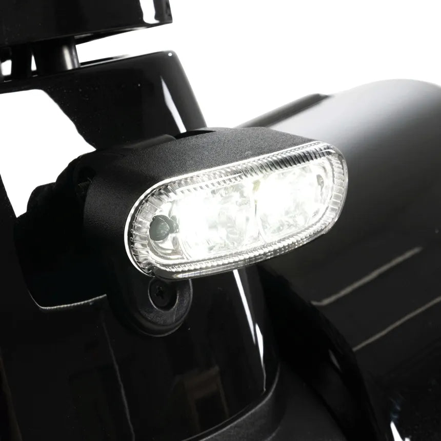 Power scooter front LED headlight closeup, oval clear lens mounted on black scooter body