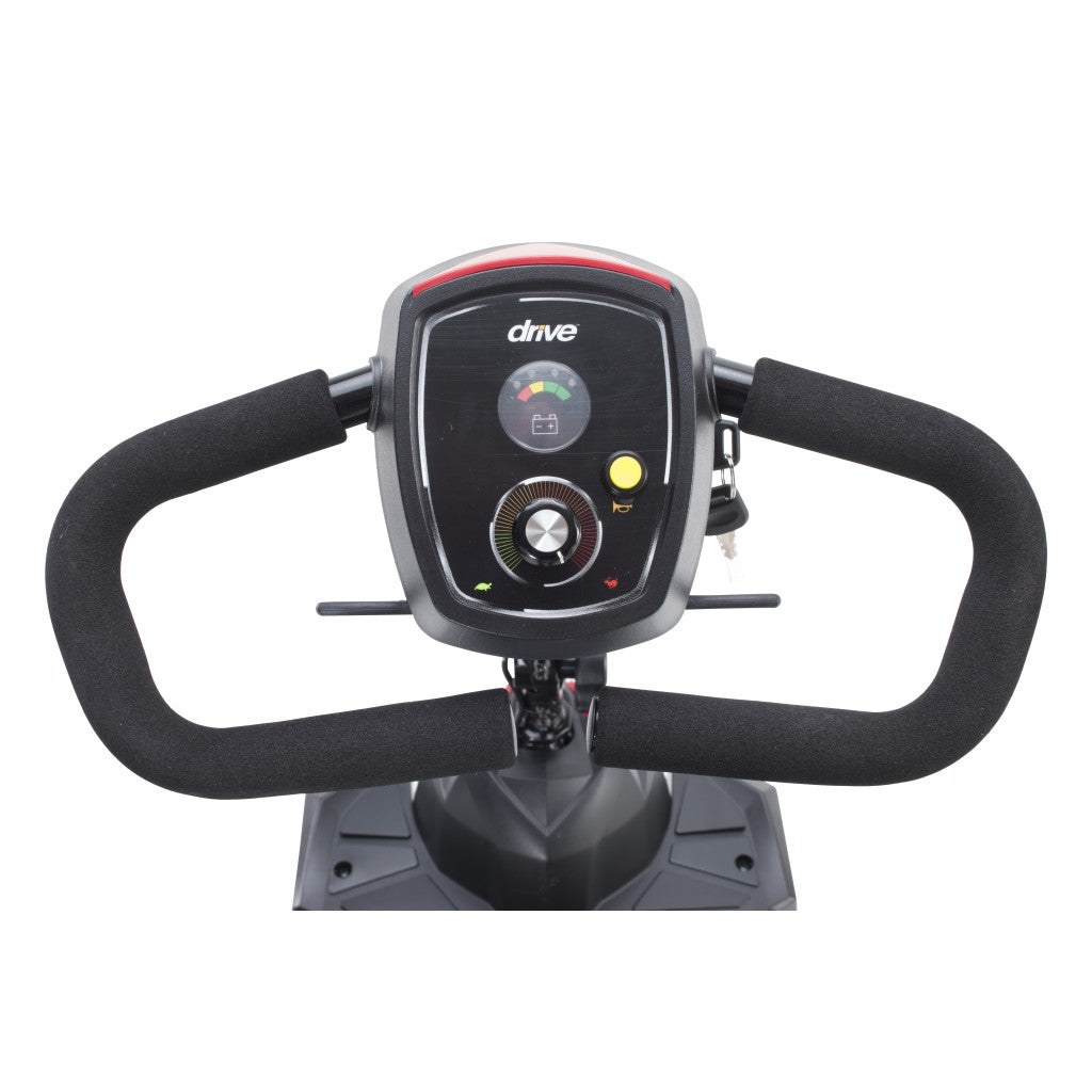 Power mobility scooter tiller with black foam handlebar, battery gauge, speed dial, horn button, and key switch