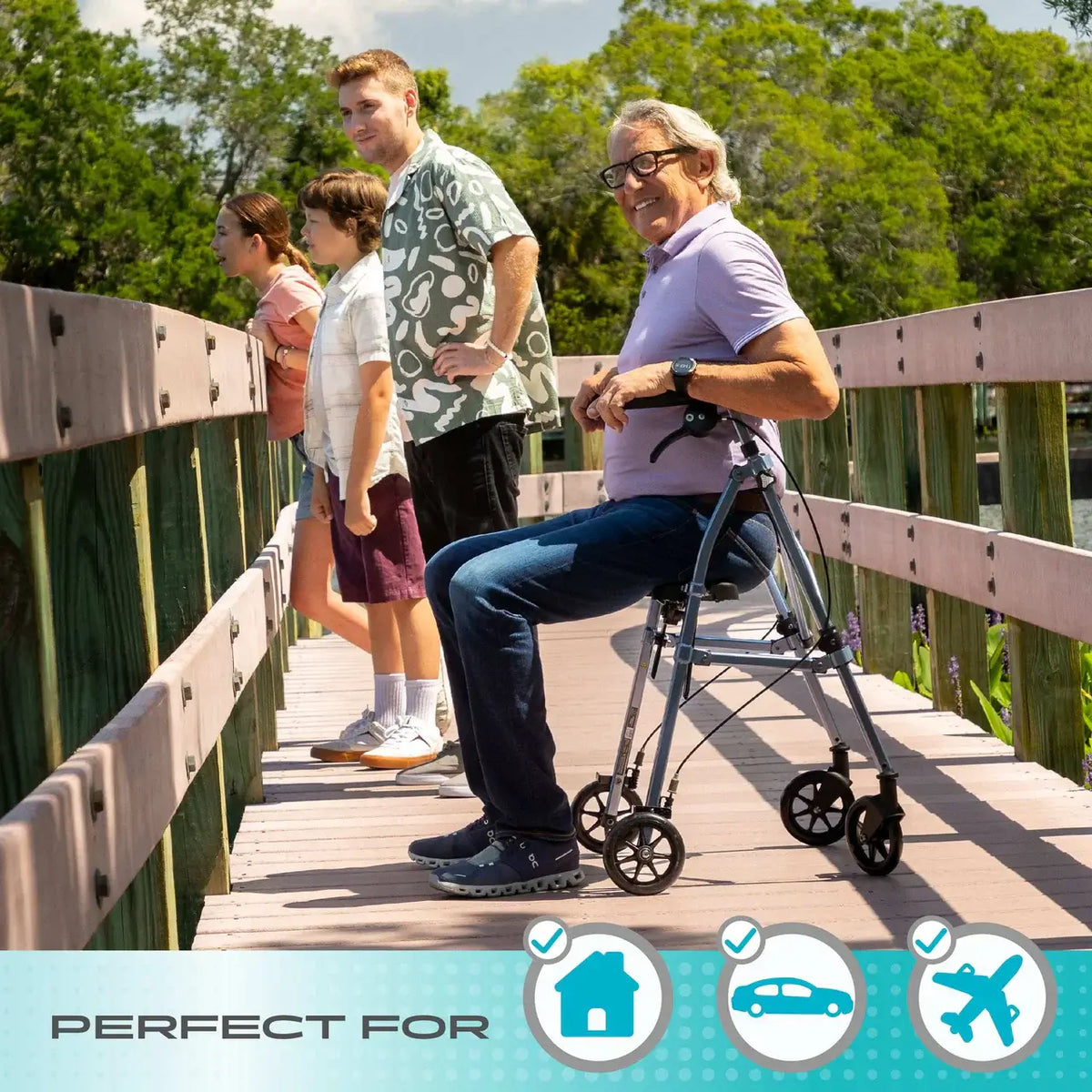 Space Saver Rollator used as a seat by a smiling older man on a wooden bridge outdoors with family nearby
